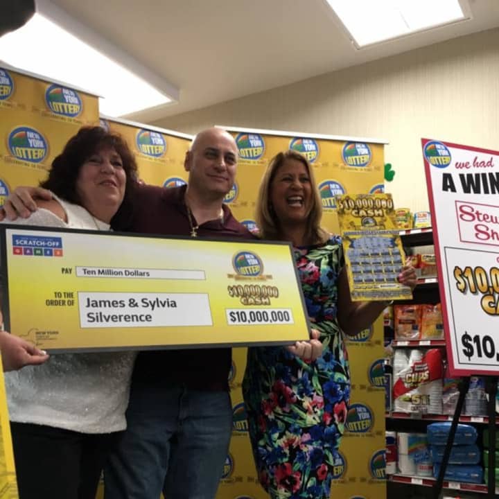 Poughkeepsie couple James and Sylvia Silverence accept an oversized check for $10 million from Lottery spokeswoman Yolanda Vega at a Stewart&#x27;s Shops store Thursday.