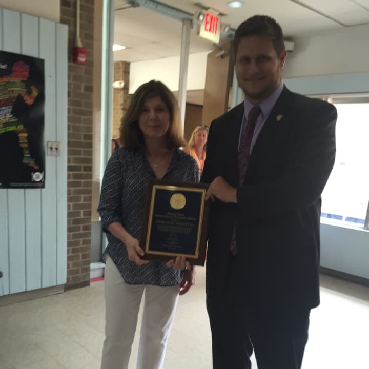 West Patent Elementary School teacher Dorothy Venditto, left, gets an Excellence In Teaching award from Thomas Scaglione, a representative of Gov. Andrew Cuomo.