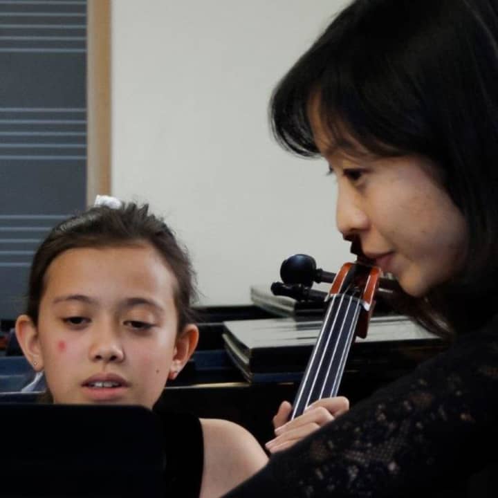 A Hoff-Barthelson student learning from one of the members of the New York Philharmonic.