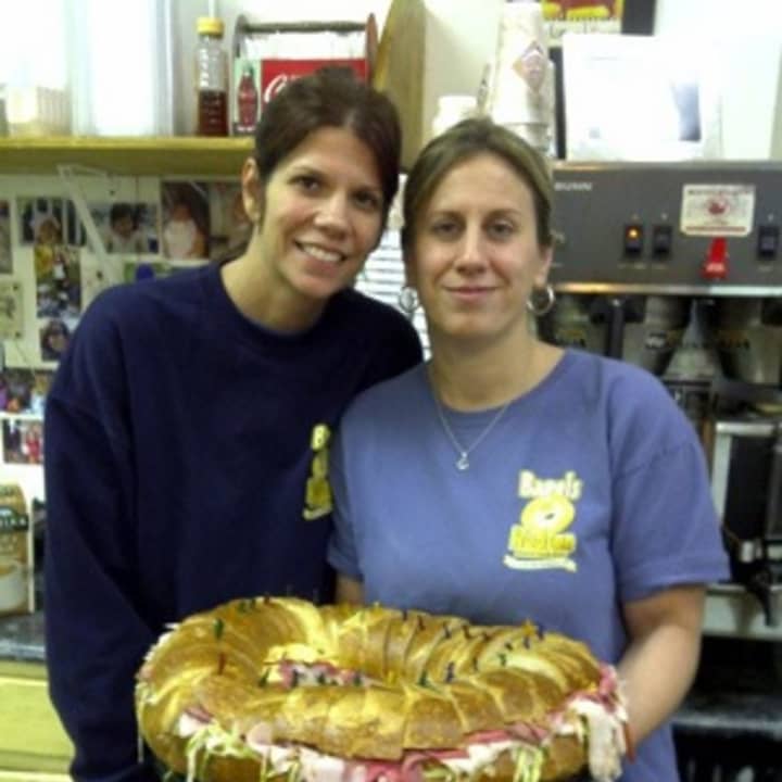 Bagels on Hudson&#x27;s Owner Debbie Liaskos and her sister, Kim Peterson, who manages the eatery, hold a giant bagel sandwich that could easily serve 28 people.