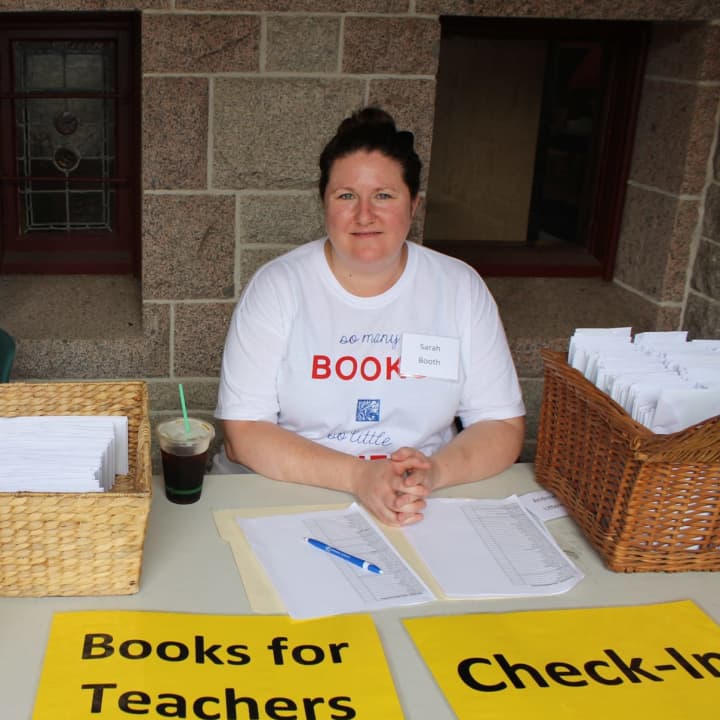 A Pequot Library volunteer is ready to sign in recipients of the Books for Teachers program.