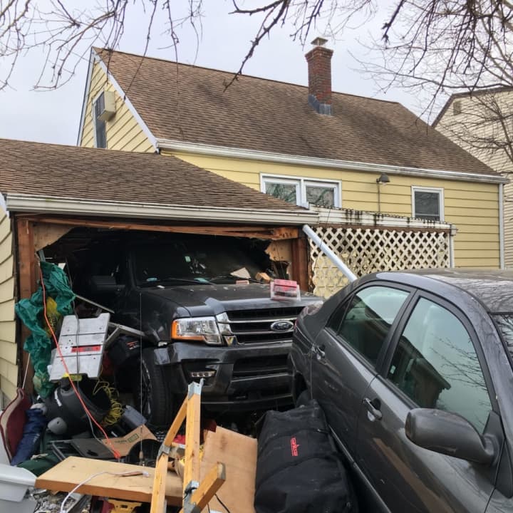 The Ford rammed the sedan straight through the back of the garage.