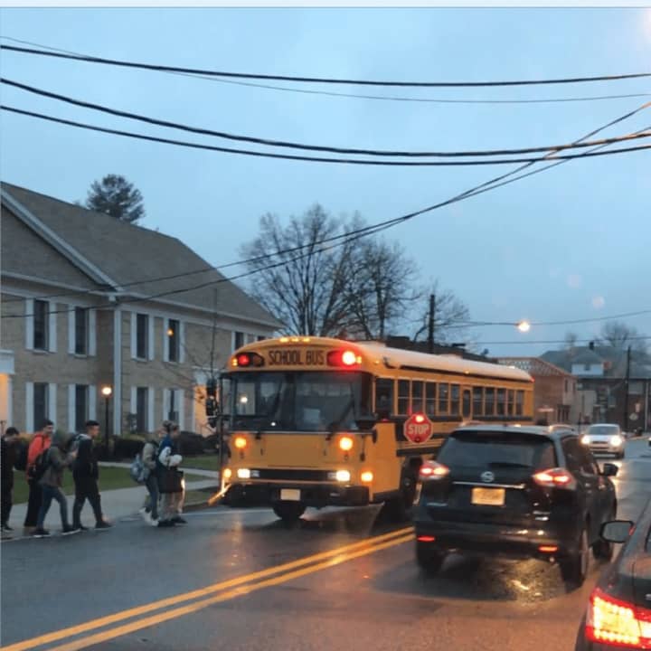 A car speeds past the school bus, ignoring the stop sign and blinking red lights in Wood-Ridge.