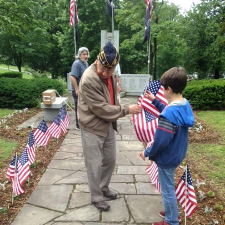 Guiseppe &quot;Joe&quot; Tanzi, left, and Ari Kotler place American flags at the veterans memorial in Patriot&#x27;s Park in Tarrytown.