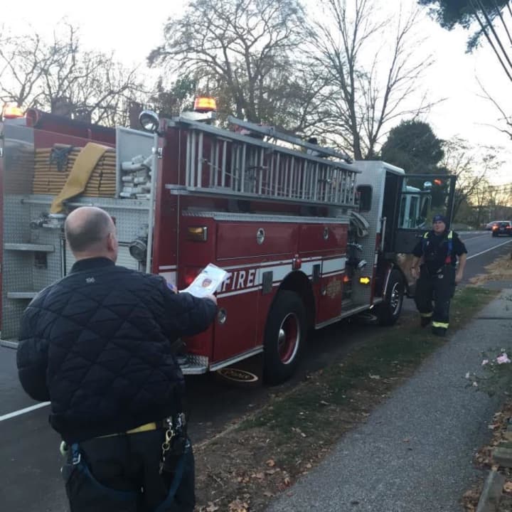 Fairfield Fire Department personnel distribute literature to neighboring houses after Monday night’s fire on South Benson Road.