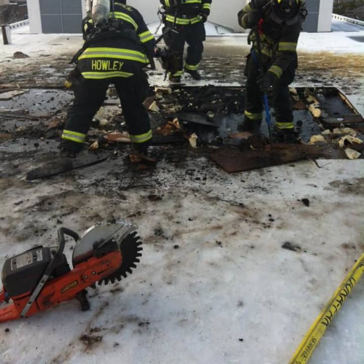 Greenwich firefighters battle a small blaze on the roof of 100 W. Putnam Ave. on Sunday morning.