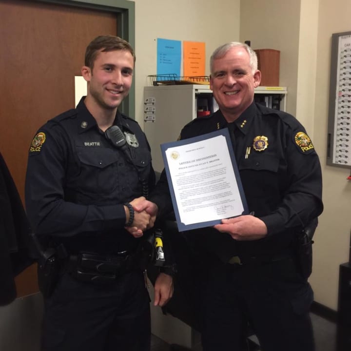 Officer Ryan Beattie receives the Officer of the Month Award from Police Chief Jim Heavey