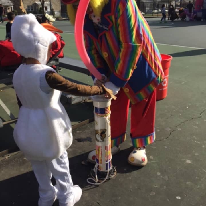 A clown makes a balloon animal.