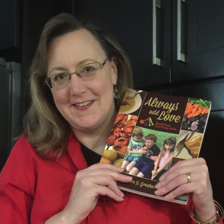 Ridgewood mom and food blogger Deidre Groehnert holds up a copy of her new book, Always Add Love. 
