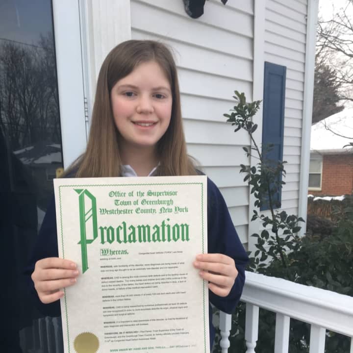 Jennifer Reilly proudly displays a proclamation from the Town of Greenburgh.