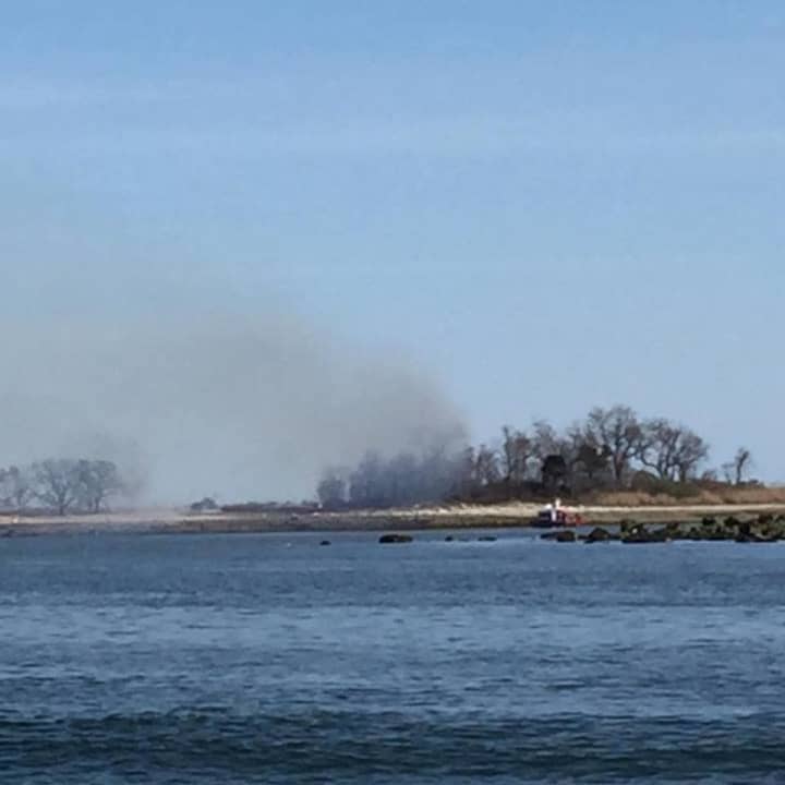 The brush fire on Grassy Island off the coast of Norwalk can be seen from the mainland.
