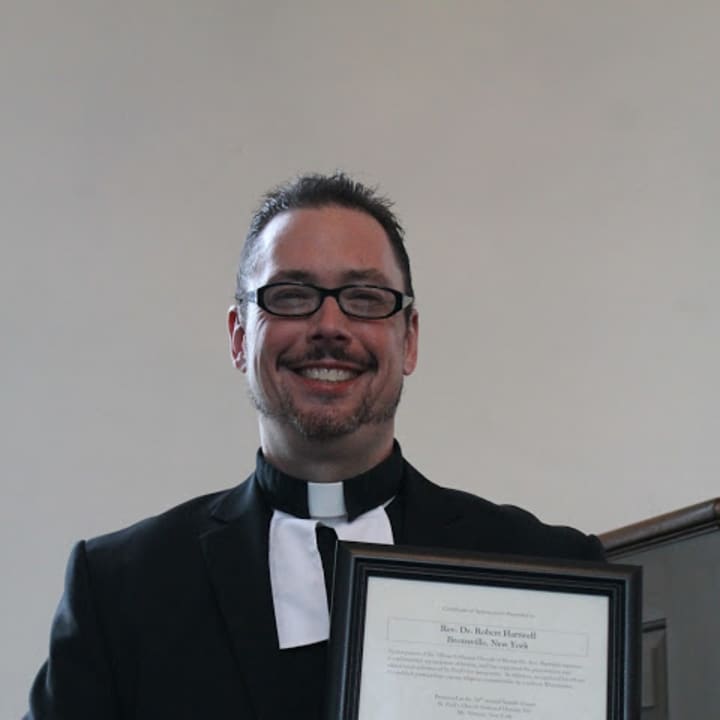 Bronxville pastor Robert Hartwell raises his award in Mount Vernon.