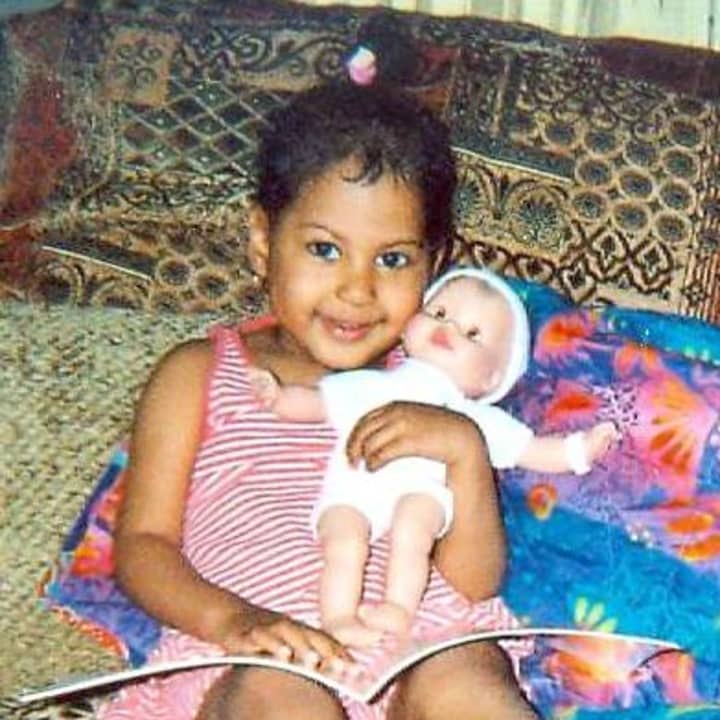 A girl cuddles with a doll she received through the Friends of Karen &quot;Holiday Adopt-A-Family&quot; last year.
