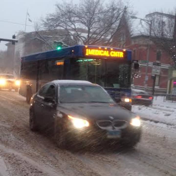 A HART bus makes its way down a snow-covered Main Street in Danbury late Tuesday afternoon. 