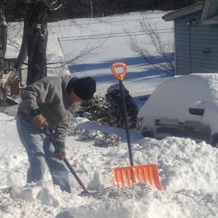 This man shoveling snow in Danbury is bundled up against the bitter cold. 