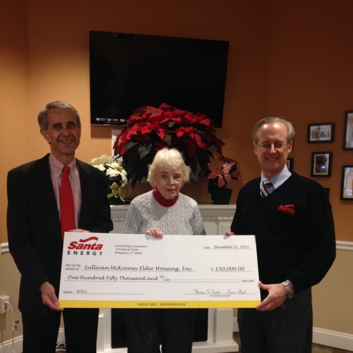 Carolyn Durgy, President of the Board of Directors of Sullivan McKinney Elder Housing, accepts the check from Santa Energy Corporation. 