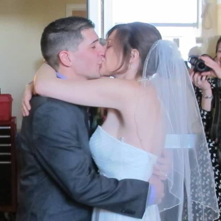 Greenwich High grads Anthony and Aly Femia kiss at their wedding at Yale-New Haven Hospital. They put their wedding together in 24 hours for Aly&#x27;s dying mother.