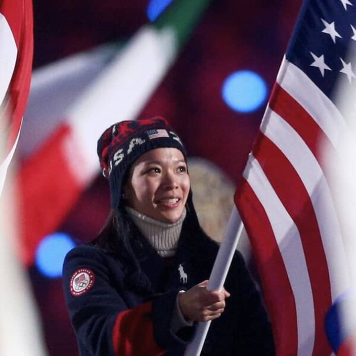 Julie Chu carries the U.S. flag at the closing ceremony in Sochi on Sunday. 