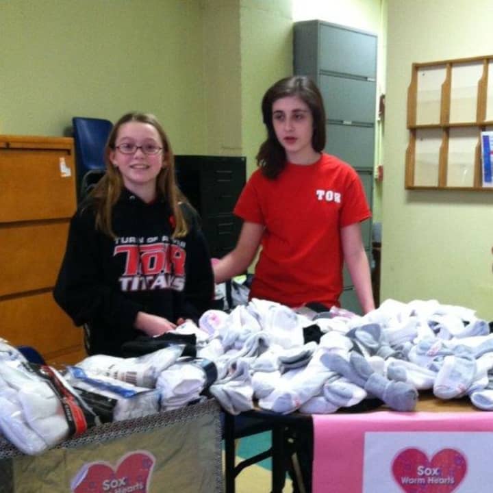 Mason Perkins and Zionna Matulis hand out socks at New Covenant House of Hospitality in Stamford. 