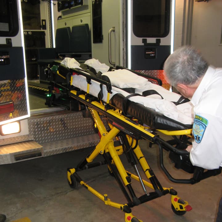 Jay Paretzky, a crew chief with the Westport Volunteer Emergency Medical Service, demonstrates one of the new stretcher hydraulic power loading systems acquired by WVEMS for each of its three ambulances.