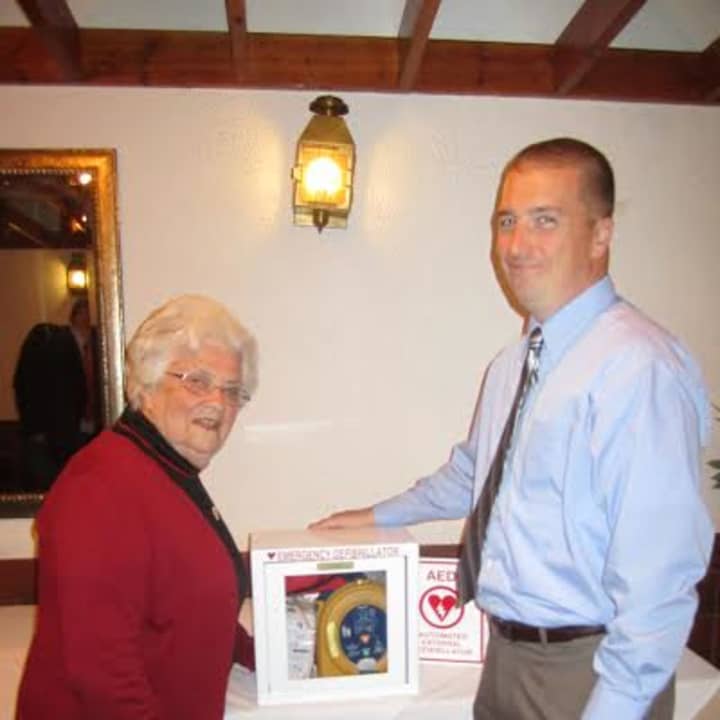 Elmsford Police Officer and PBA President Dennis Donohue presents a new defibrillator to Our Lady of Carmel School Principal Sister Mary Stephen on Tuesday, May 6.