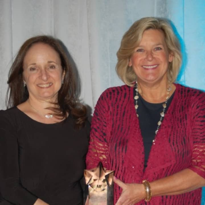 Diane Rosenthal, executive director of NFTE Fairchester, gives Ellen Lynch, executive director of Food Bank for Westchester, the award for Exemplary Volunteer Service . 