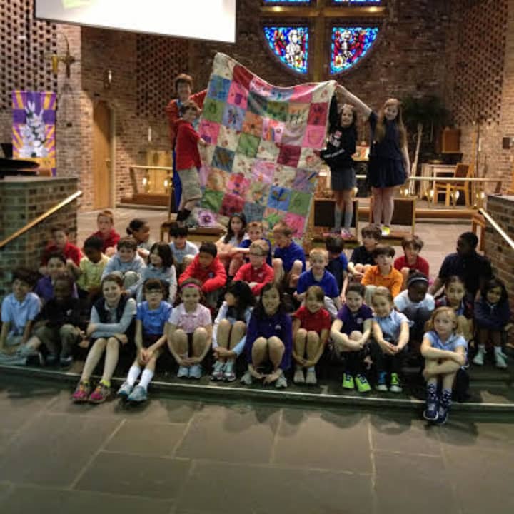 The Chapel School third graders proudly display their quilt.