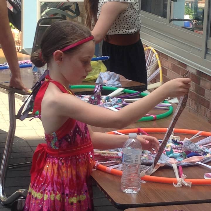 A young artist tries her hand at weaving a dream catcher at a prior event.