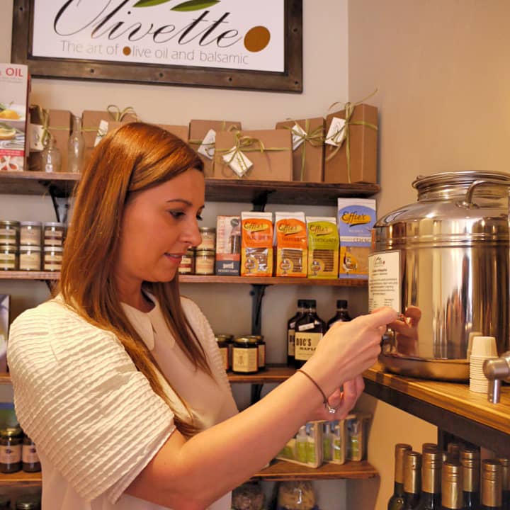 Alina Lawrence, owner of Olivette, pours out a taste of one of the olive oils in her store.