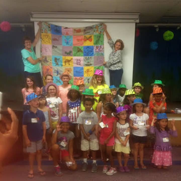Vacation Bible School participants proudly display their quilt.