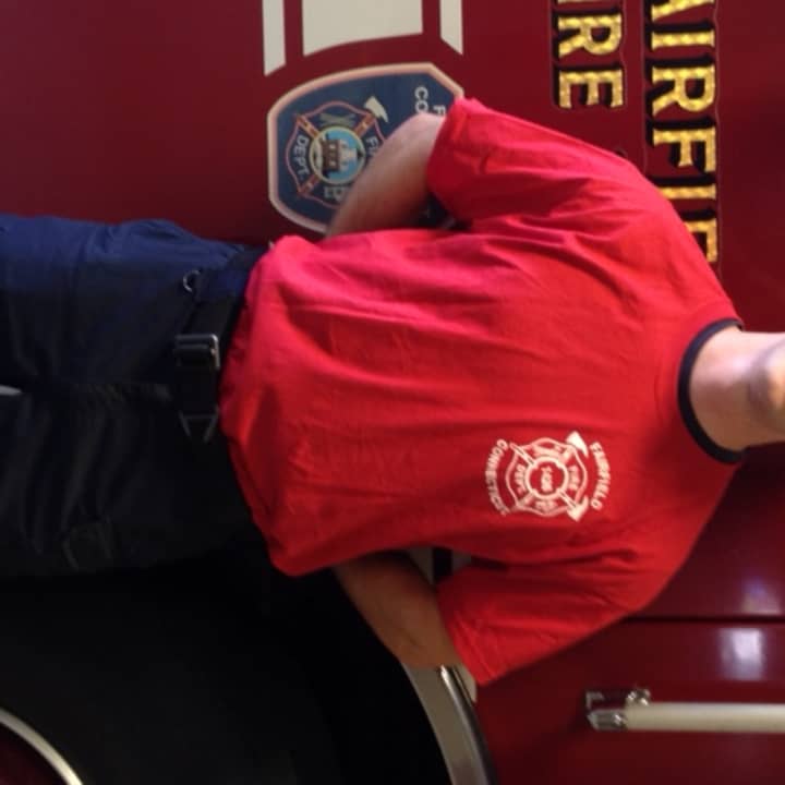 Firefighter Jordan Charney in a red uniform t-shirt.