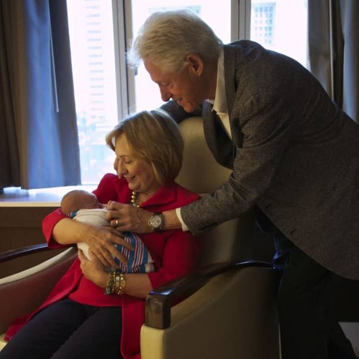Proud grandparents Bill and Hillary Clinton hold their first grandchild, Charlotte.