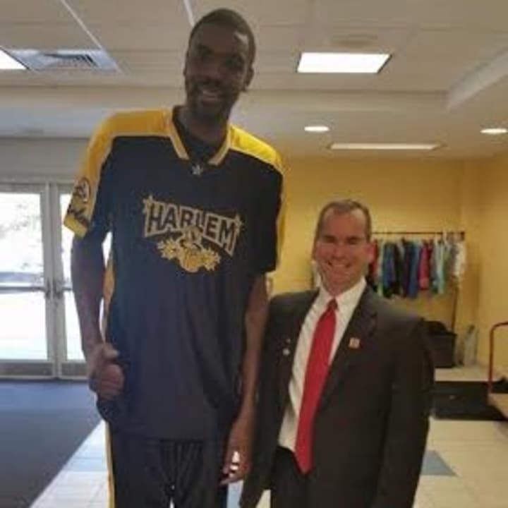 Rotary president Eric Lebenson stands with a Harlem Magic Masters player.