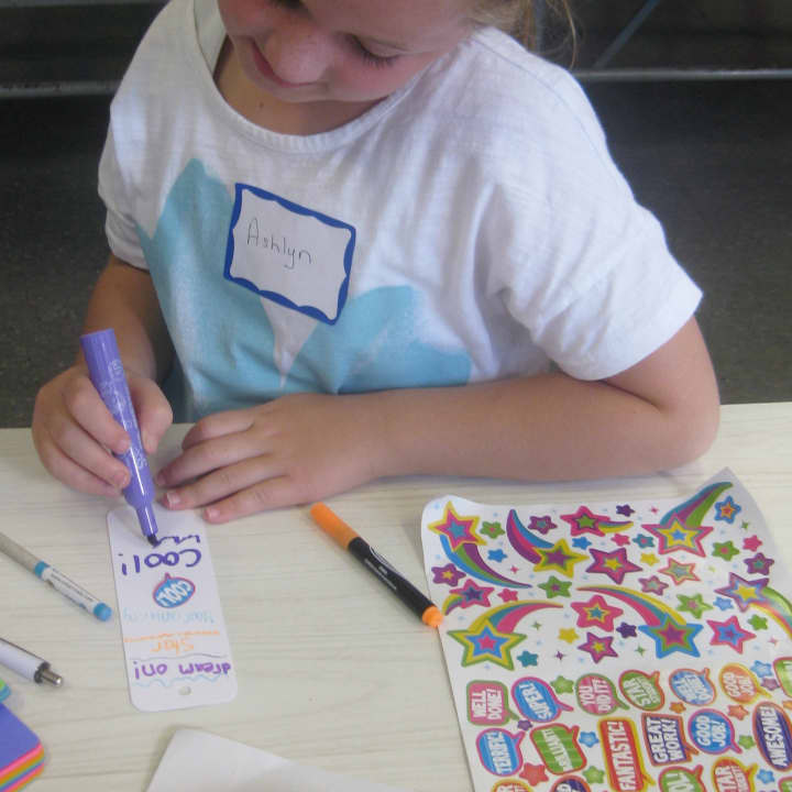 Royle student Ashlyn Fran makes a bookmark for a Bridgeport foster care child.