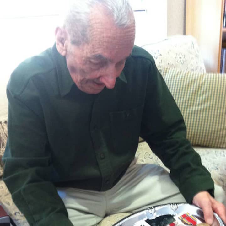 Greenwich resident Vincent Meli, 92, looks at his medals for service in the US Army in World War II. He received them Monday, almost 70 years after the war ended, from U.S. Sen. Richard Blumenthal.