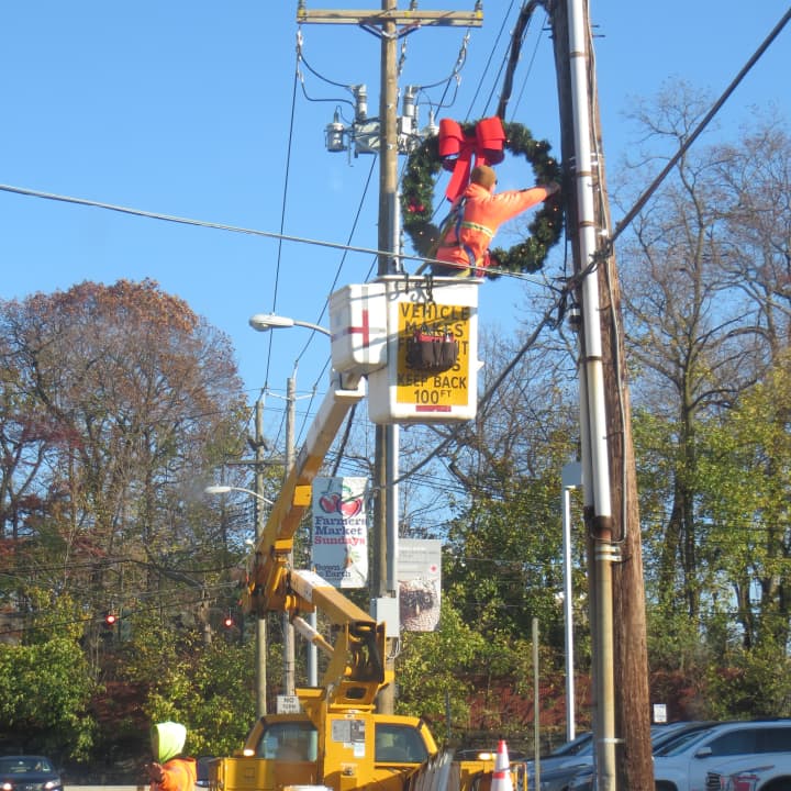 A city public works crew decorating a utility pole for the holidays along Purdy Street in Rye on Wednesday afternoon.