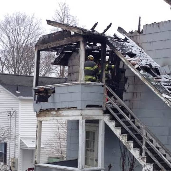 Fire officials climb the stairs of a Danbury home that caught fire overnight. 