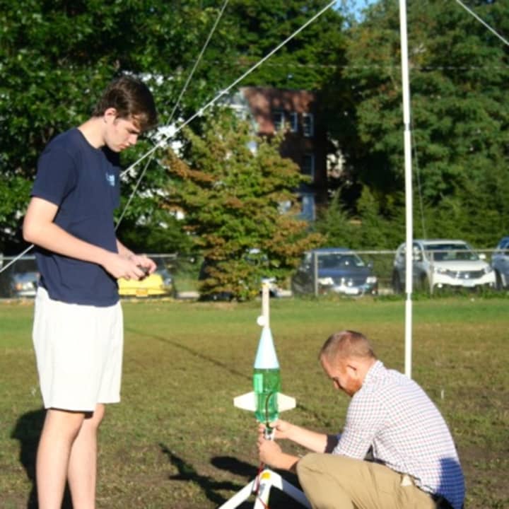 Advanced physics teacher Jonathan Peter and student Hank Thomas participating in a rocketry lab.