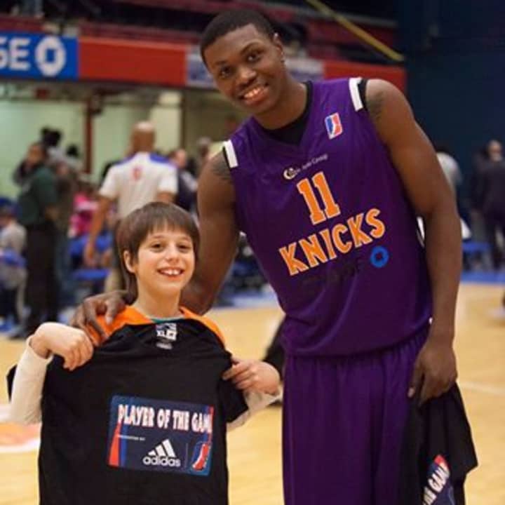 ADIDAS Player of the Game Cleanthony Early poses with ADIDAS Fan of the Game and birthday boy, Samuel Leviatin from Tarrytown.