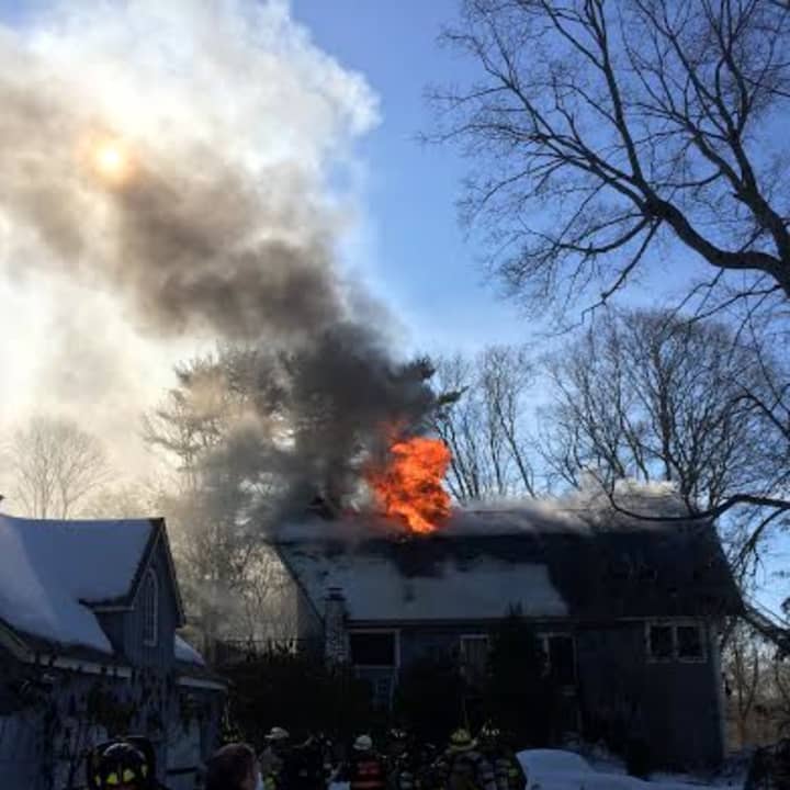 Flames shoot from the roof of the three-story home at 266 Range Road in Wilton. 