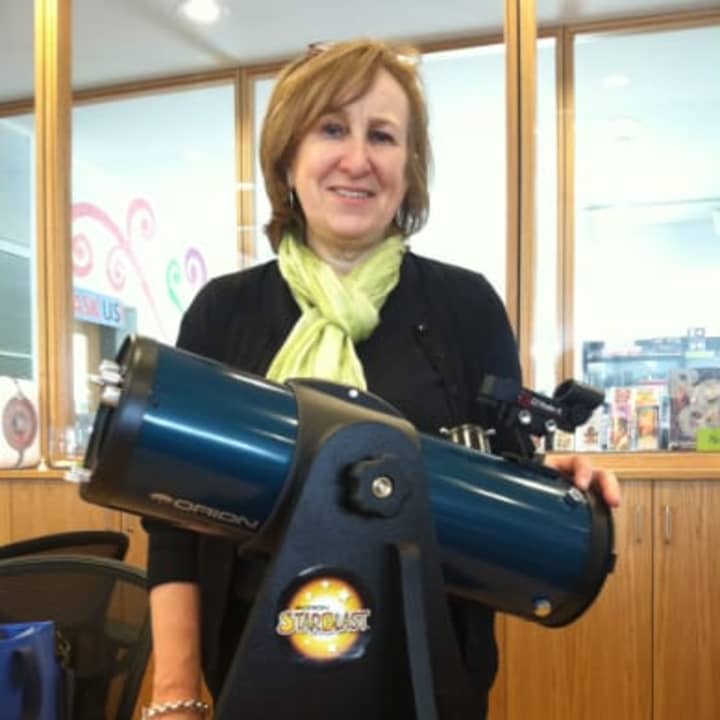 Susan Lauricella, head of Teen Services, Maker Space Coordinator at Wilton Library stands by the telescope that the library is now lending. 
