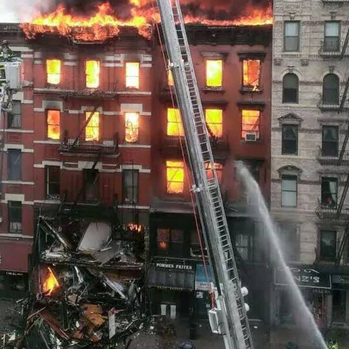 An explosion and five-alarm fire have caused at least one building in Lower Manhattan to collapse. 