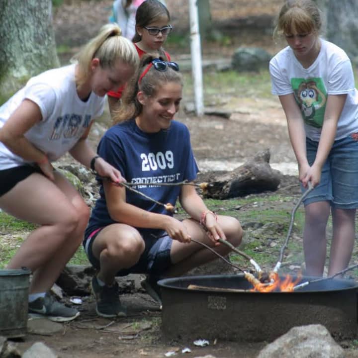 Girls can enjoy a variety of traditional outdoor activities at Camp Katoya, including cooking over a fire. 