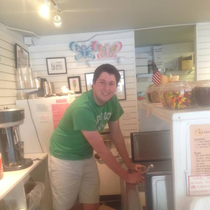 Michael Williams, a senior at Wilton High, scoops up ice cream at Scoops. 