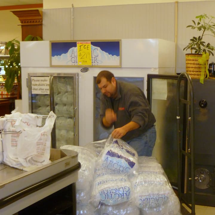 A worker at DeCicco Family Market in Cross River receives a shipment of ice. The store got its power back Thursday evening and has been restocking shelves ever since.