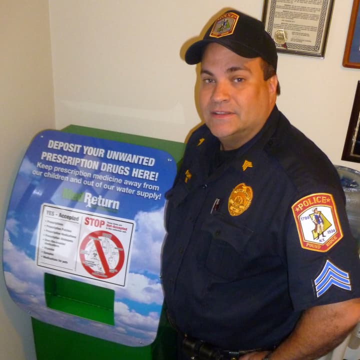 Pound Ridge police Sgt. Tom Mulcahy will oversee the prescription drug disposal program. Here he stands next to the disposal receptacle in the police station lobby.