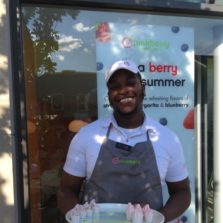 Azah, a pinkberry employee, offers samples outside the Greenwich Pinkberry location in Greenwich. It is now a company-owned location. 