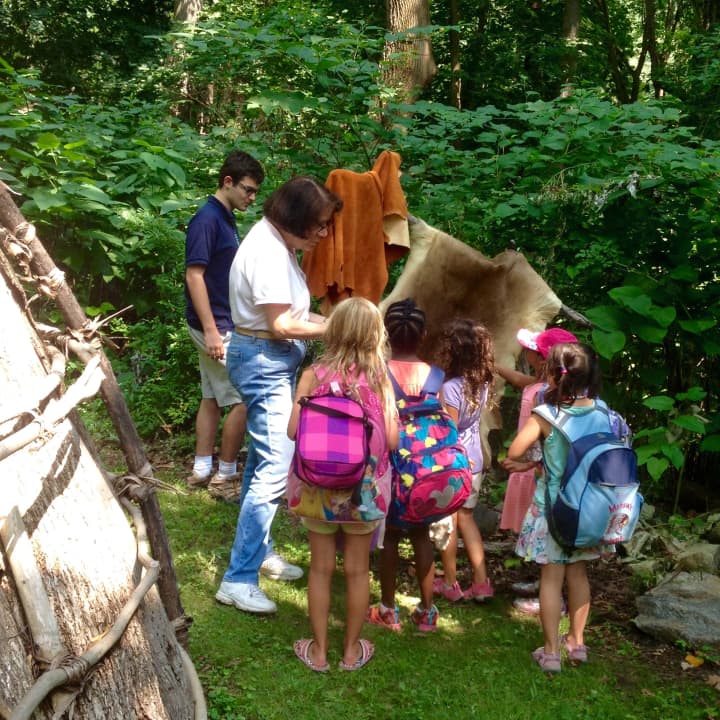 Weinberg Nature Center staff shows campers how Native Americans used a stretch rack to treat animal hides.