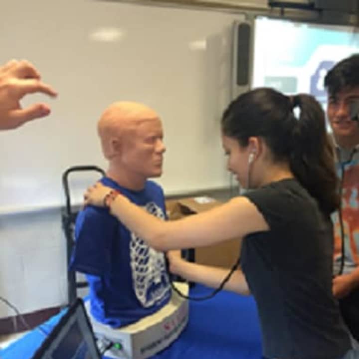 An Ossining students learns how to take vital signs. 