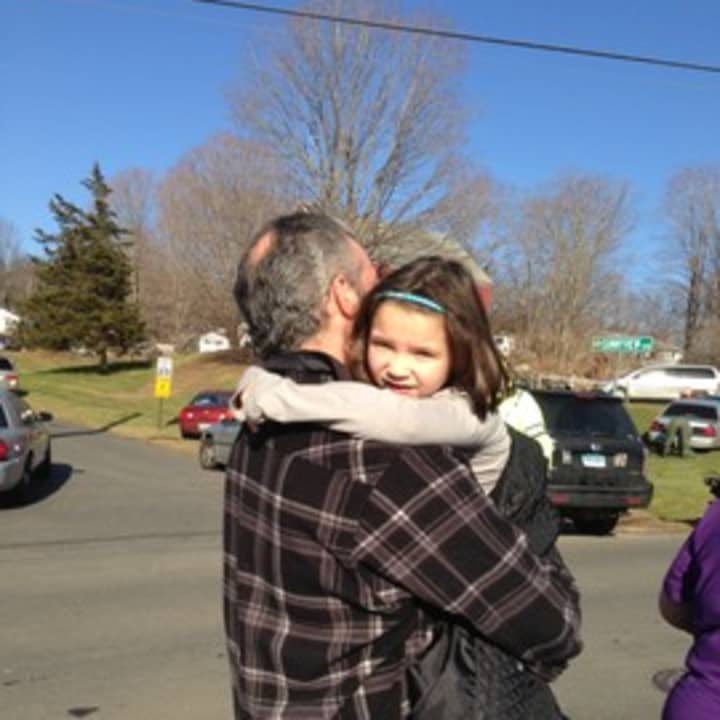 A parents and child reuniting Friday morning after a school shooting in Newtown, Conn.